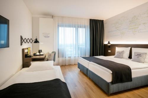 ein Hotelzimmer mit 2 Betten und einem Fenster in der Unterkunft JUFA Hotel Hamburg HafenCity in Hamburg
