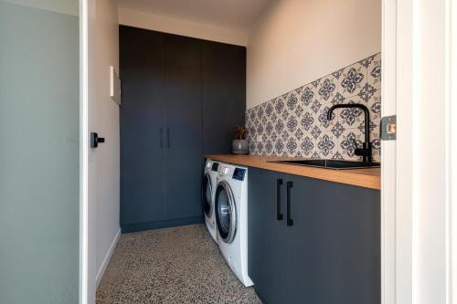 a kitchen with a washing machine and a sink at The Cove Tasmania in Devonport