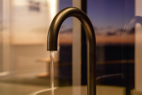 a kitchen sink with water coming out of a faucet at The Cove Tasmania in Devonport