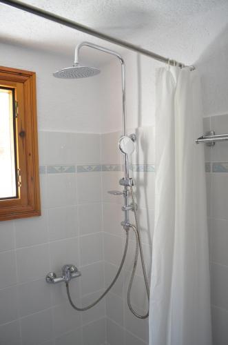 a shower with a shower curtain in a bathroom at Kalokairi Cottage in Skopelos Town