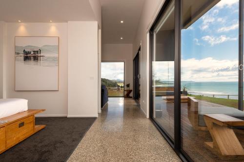 a bedroom with a bed and a view of the ocean at The Cove Tasmania in Devonport