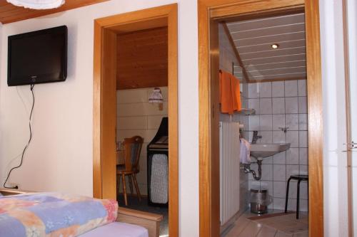 a room with a kitchen with a sink and a television at Ferienwohnung Bickel in Sankt Anton im Montafon