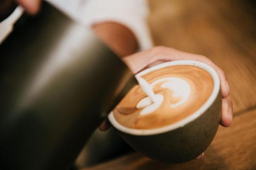 a person is holding a cup of coffee at The Old Bakery in Kenilworth