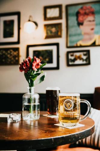 a table with a vase of flowers and a drink at The Old Bakery in Kenilworth