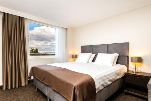 ein Schlafzimmer mit einem großen Bett und einem Fenster in der Unterkunft Adoryal Hotell in Tallinn
