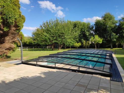 a glass pool in a park with trees in the background at Demeure du Haut Canteloup in Honfleur