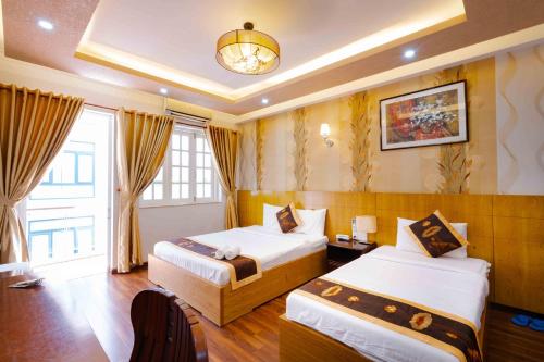 Habitación de hotel con 2 camas y lámpara de araña. en Saigon Amigo Hotel, en Ho Chi Minh