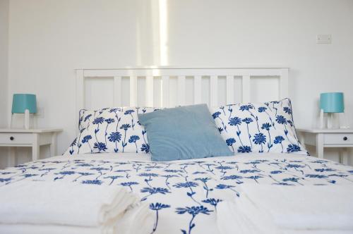 a bed with blue and white sheets and pillows at La Silvana B&B in Coriano