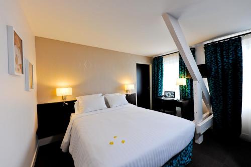 Un pat sau paturi într-o cameră la Le Saint-Pierre