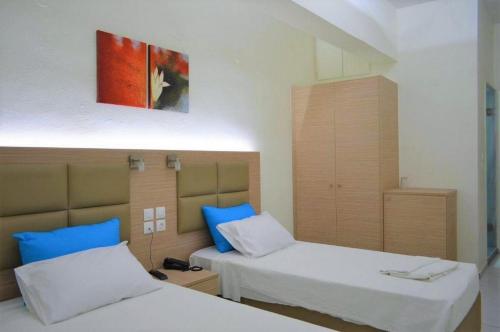 a bedroom with two beds with blue pillows at Sun Boutique Hotel (Adults Only) in Amoudara Herakliou