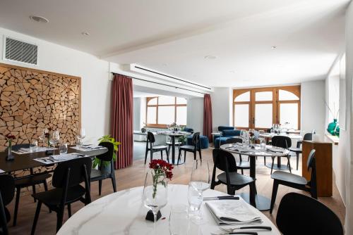 una sala da pranzo con tavoli, sedie e finestre di Le Sauvage a Friburgo