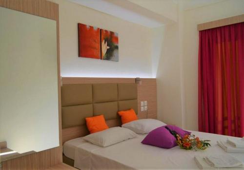 a bedroom with a bed with orange and purple pillows at Sun Boutique Hotel (Adults Only) in Amoudara Herakliou