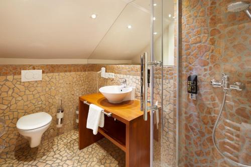 W łazience znajduje się toaleta, umywalka i prysznic. w obiekcie Hotel Heide Residenz w mieście Paderborn