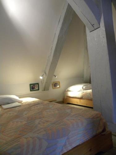 une chambre avec deux lits dans un grenier dans l'établissement LE CENTRAL studio mezzanine, à Cauterets