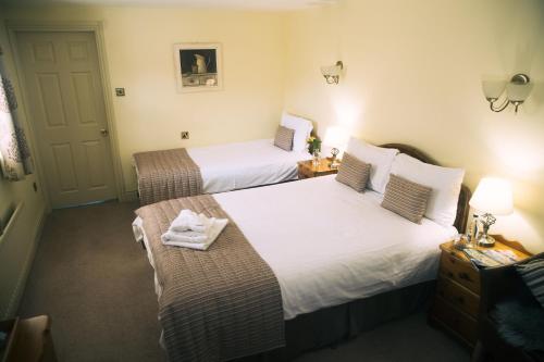 a hotel room with two beds with towels on them at The Old Bakery in Kenilworth