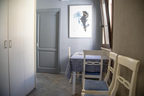 a dining room with a table and a white door at Le Plejadi in Castellammare del Golfo