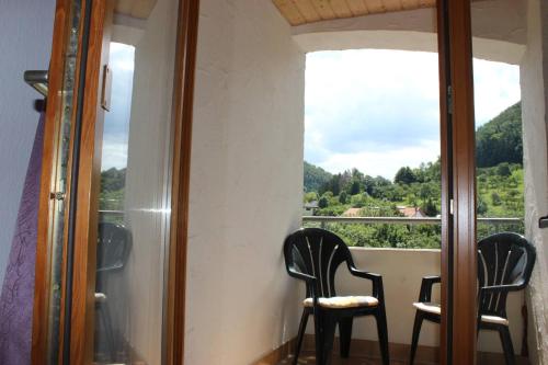 two chairs sitting in a room with a window at Hotel Garni Silberdistel in Nenningen