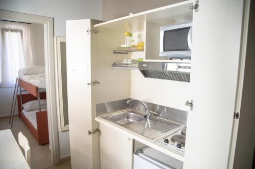 a small kitchen with a sink and a microwave at Le Plejadi in Castellammare del Golfo