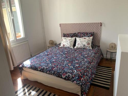 Schlafzimmer mit einem Bett mit gemustertem Kopfteil und Kissen in der Unterkunft Au Plaisir d Etape- Gîte touristique Condom in Condom