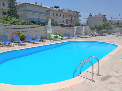 a large swimming pool with chairs and a building at Sun Boutique Hotel (Adults Only) in Amoudara Herakliou
