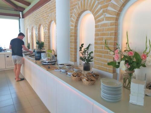 a man standing in a kitchen preparing food at Sun Boutique Hotel (Adults Only) in Amoudara Herakliou
