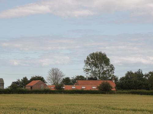 a group of red brick buildings in a field at Kingfisher Corner in Great Driffield