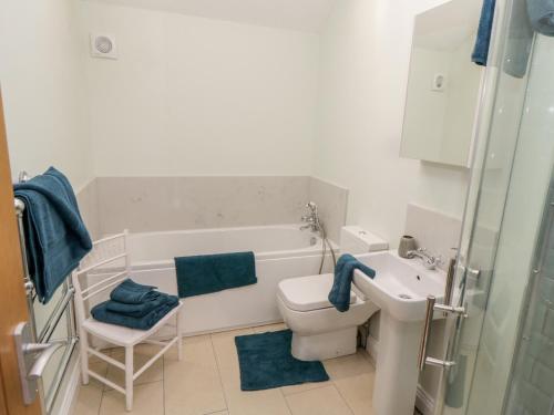a bathroom with a tub and a toilet and a sink at The Stables in Great Driffield