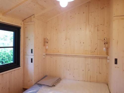 a room with wooden walls and a window at Camping Le Mouliat in Moncrabeau