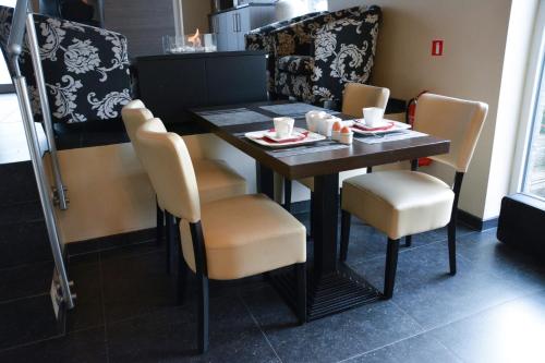 a table and chairs with cups and plates on it at B&B Afrodite in Zonnebeke