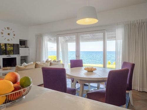 een woonkamer met een tafel en uitzicht op de oceaan bij Villa Miriam - Klodge in Olbia