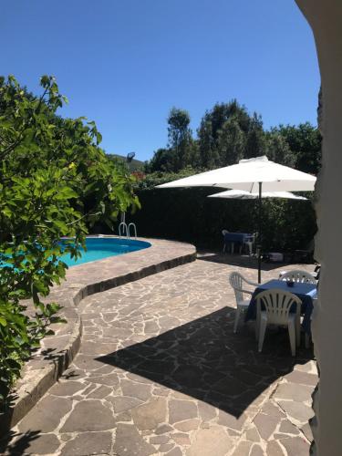 a patio with a table and an umbrella and a pool at Casa Gramapa in Rocca Priora