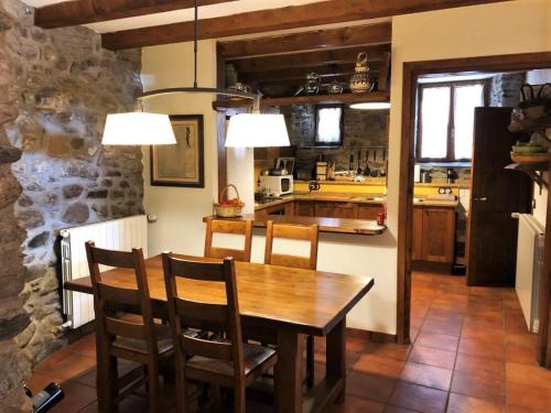 une cuisine et une salle à manger avec une table et des chaises en bois dans l'établissement Casa de Pueblo en Ur ideal 8 personas, à Ur