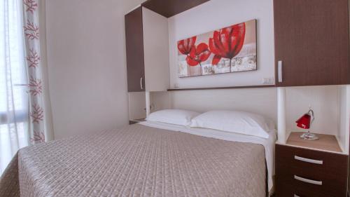 a bedroom with a bed and two pictures on the wall at Residence Il Corallo - Guitgia in Lampedusa
