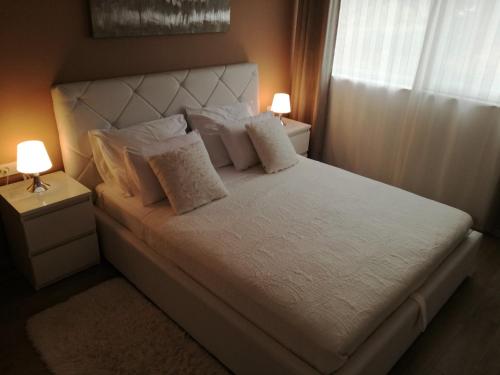 a bedroom with a white bed with two lamps at Ivana Šibenik in Šibenik