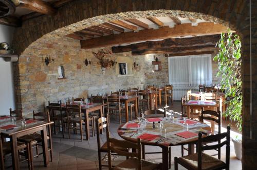 a dining room with tables and chairs and a brick wall at Hôtel Restaurant La Casera in Clarac