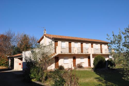a house with a balcony on the side of it at Hôtel La Casera in Clarac
