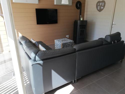 a large couch in a living room with a television at maison 3 chambres à 200 m de la plage des Lacs de l Eau d Heure in Froid-Chapelle