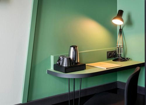 a kitchen area with a coffee table and a lamp at Hôtel Tandem - Boutique Hôtel in Strasbourg