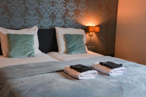 a bedroom with a bed with towels on it at B&B Afrodite in Zonnebeke