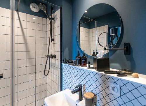 a bathroom with a shower and a sink and a mirror at Hôtel Tandem - Boutique Hôtel in Strasbourg