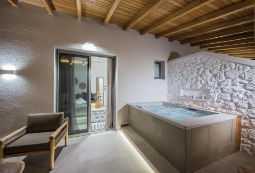 a bathroom with a soaking tub and a chair at Bohemia Luxury Living in Hanioti