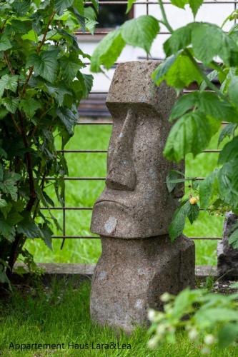 a stone statue in a garden with a fence at Appartement Lara & Lea in Zell am Ziller