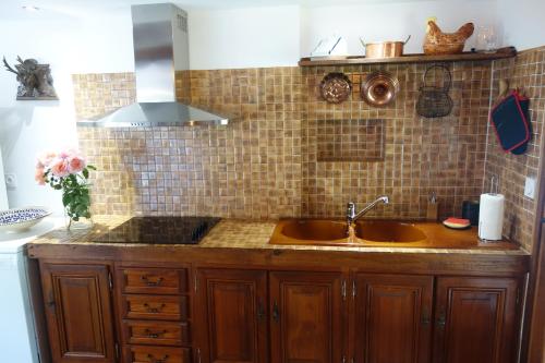 cocina con fregadero y pared de azulejos en Le cottage du Coudray, gîte avec chalet sauna, 