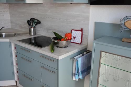 a kitchen with a sink and a bowl of vegetables at Ostsee-Karo in Graal-Müritz