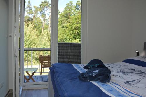 ein Schlafzimmer mit einem Bett und einem großen Fenster in der Unterkunft Ostsee-Karo in Graal-Müritz