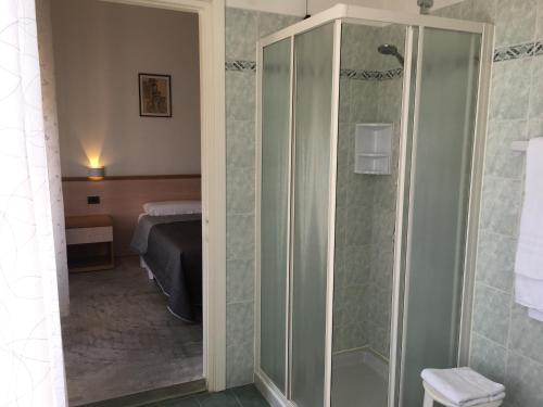 a bathroom with a glass shower with a bed at Hotel Trieste in San Giórgio di Nogaro