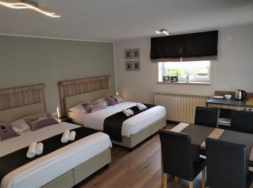 Habitación de hotel con 2 camas, mesa y sillas en Yellow Dreamhouse, en Postojna