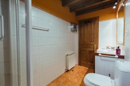 a bathroom with a toilet and a sink at Casa Rural La Galana in Sames