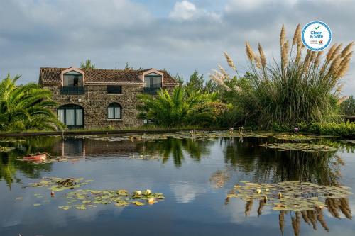 a pond with lily pads in front of a building at Casas do Termo in Lagoa