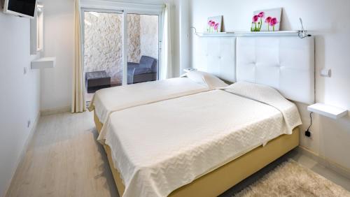 เตียงในห้องที่ Apartamentos Mónaco by Garvetur